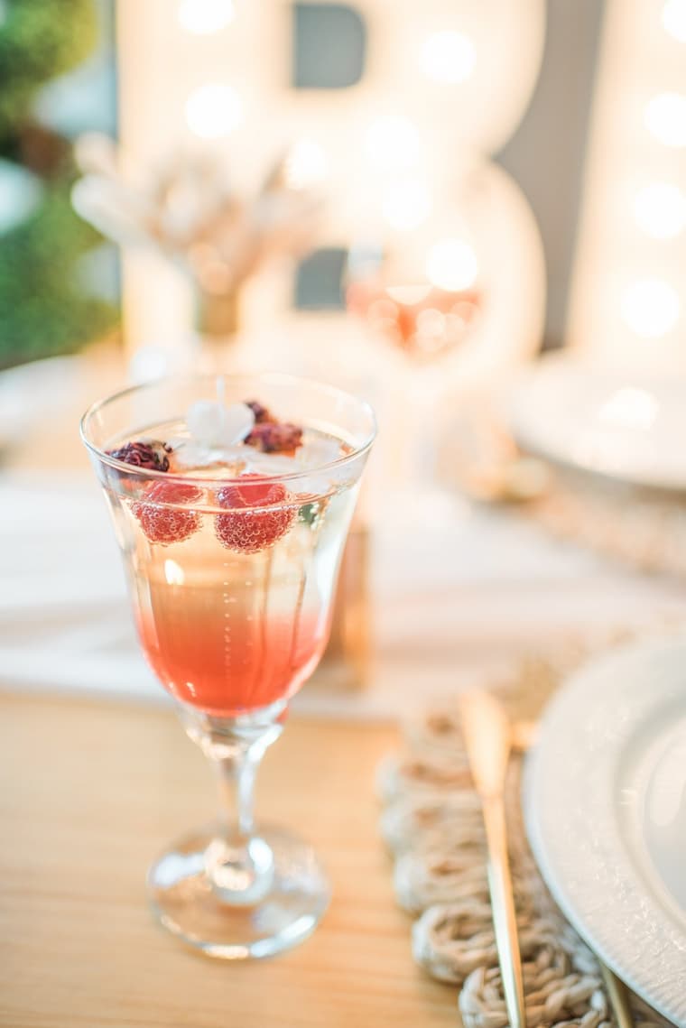 Elegant raspberry and floral signature cocktail at a luxury wedding reception