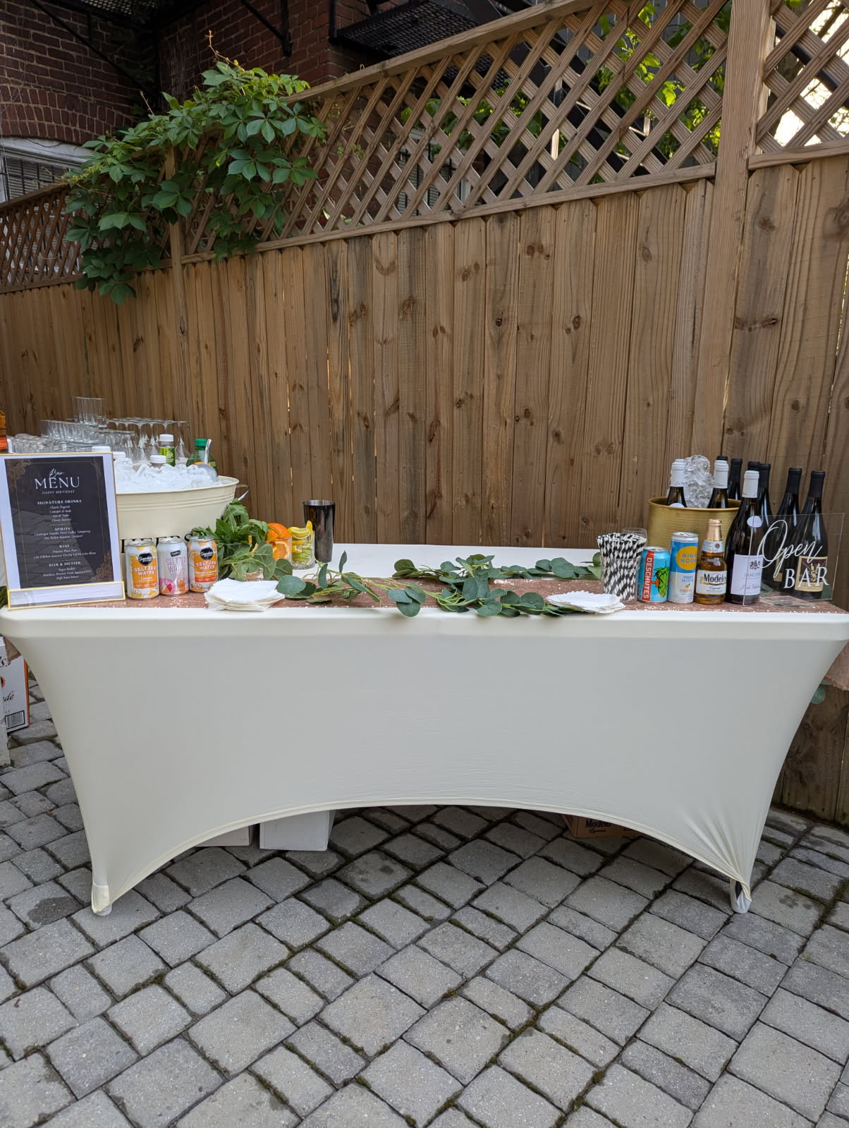 Ivory wedding bar with eucalyptus garland for outdoor patio party