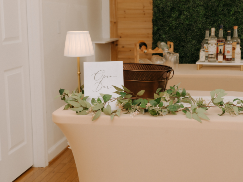 adding garland and greenery to diy wedding bar